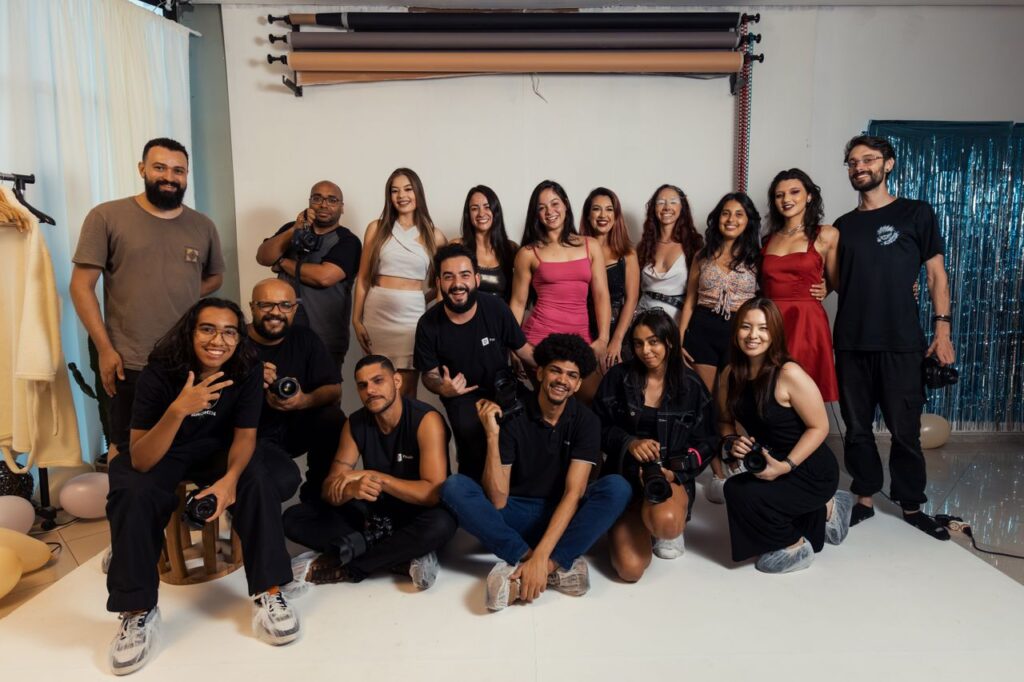 A diverse group of photographers posing together in a studio setting in Brazil, showcasing camaraderie.
