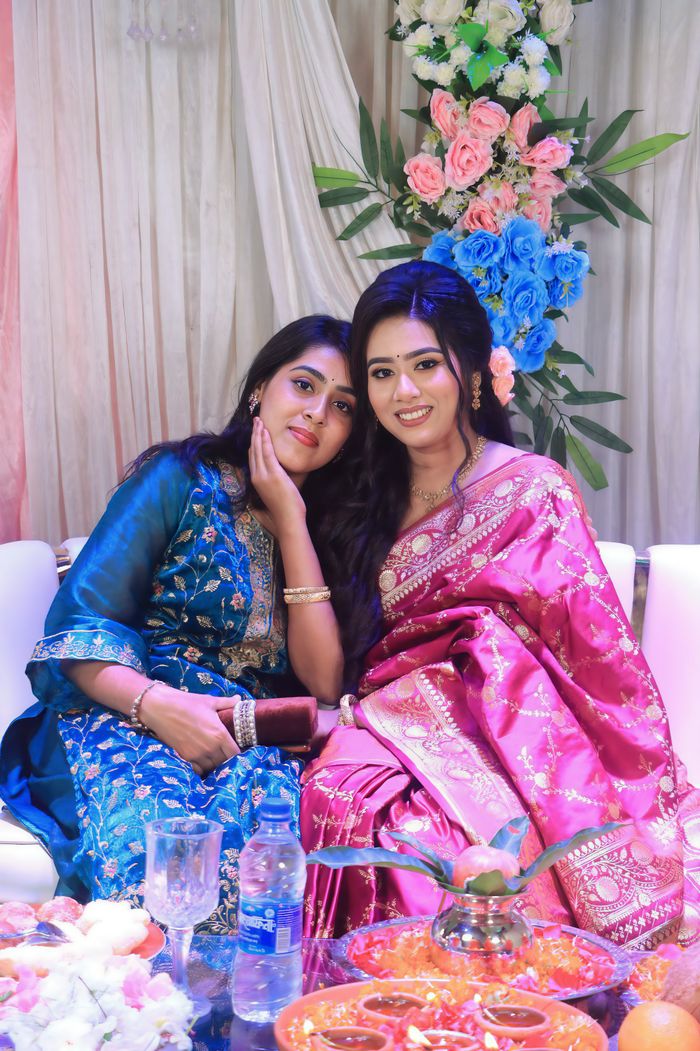 Two women in beautiful saris enjoying a festive Indian event.